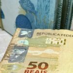 Cédulas de 50 reais empilhadas e em close-up